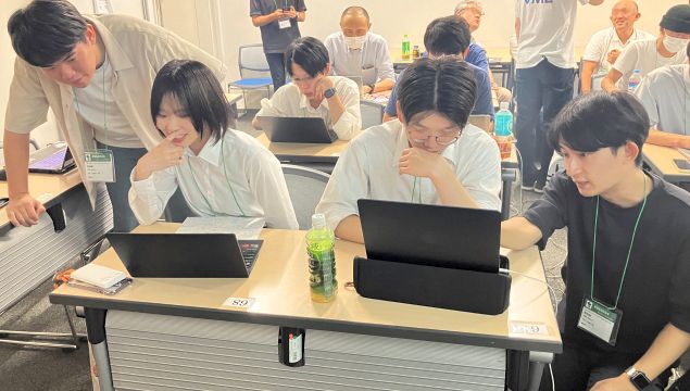 参加者のプログラム開発を補助する菖蒲池君（左）と山﨑君（右）